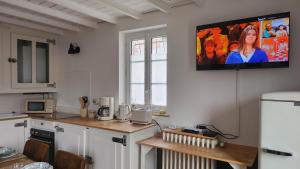 a kitchen with a tv hanging on the wall at Le Clos des Souvenirs in Étretat +24 photos