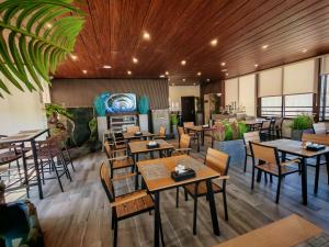 a restaurant with wooden ceilings and tables and chairs at Friends Hotel Jordan in Amman