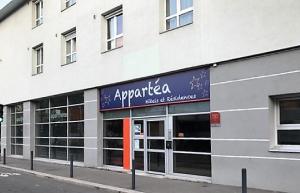 un bâtiment avec un panneau sur son côté dans l'établissement Appartéa Grenoble Alpexpo, à Grenoble