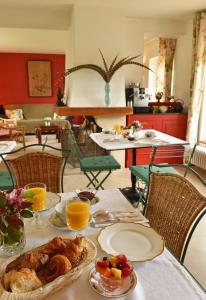 a table with a plate of food and orange juice at Chateau le Quesnoy in Chevrières +45 photos