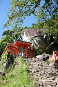 a red temple on top of a rocky mountain at 和の宿 禅 in Nachikatsuura
