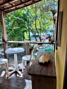 a porch with a table and chairs and a view of the forest at Mar de Moreré in Cairu +23 photos
