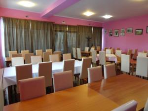 a dining room with tables and chairs and pink walls at Prenoćište "Magnus" in Slavonski Brod