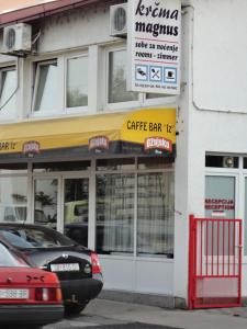 a coffee shop with cars parked in front of it at Prenoćište "Magnus" in Slavonski Brod