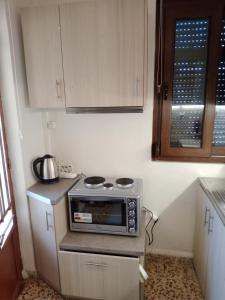 a small kitchen with a microwave on a counter at 150 metres from the beach dafnes Patra in Patra