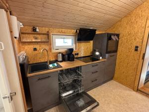 a small kitchen with a sink and a refrigerator at Tiny House mit Garten und Sauna in Karbach