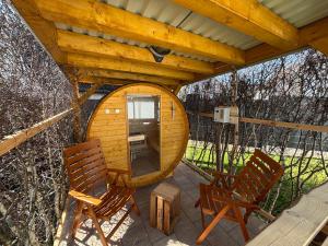 a wooden cabin with two chairs and a large wooden orb at Tiny House mit Garten und Sauna in Karbach