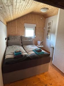 a bedroom with a bed with two towels on it at Tiny House mit Garten und Sauna in Karbach