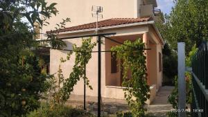 a house with a fence and some grape vines at 150 metres from the beach dafnes Patra in Patra