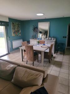 a living room with a table and a couch at Maison cosy in Biganos