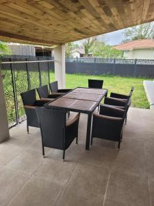 a wooden table and chairs on a patio at Maison cosy in Biganos