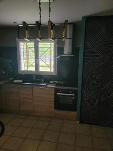 a kitchen with a window and a sink and a stove at Maison cosy in Biganos