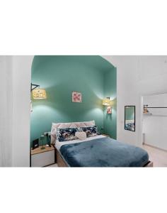 a bedroom with a bed with a blue wall at Casetta FRM home in Naples