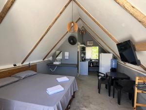 a bedroom with a bed and a desk and a tv at Condomíno dos Chalés in Porto Seguro