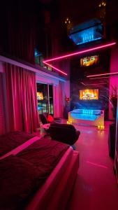 ein Zimmer mit zwei Betten und einem Kamin mit rosa Lichtern in der Unterkunft Apartament dla dwojga z jacuzzi na wyłączność in Świecie