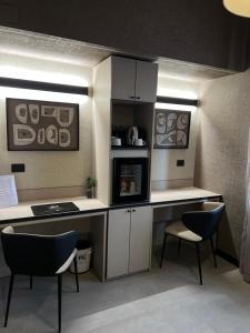 a kitchen with a desk and two chairs and a microwave at Hotel La Pace in San Mauro Torinese