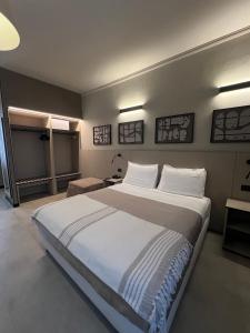 a bedroom with a large bed with white sheets and pillows at Hotel La Pace in San Mauro Torinese