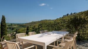 a white table and chairs with a view of a mountain at Borgo Belfiore in Arcevia +26 photos
