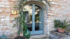 a blue door on a brick building with potted plants at Borgo Belfiore in Arcevia