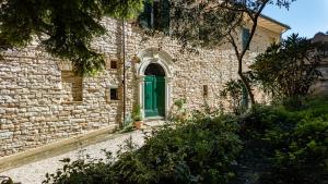 a brick building with a green door on it at Borgo Belfiore in Arcevia