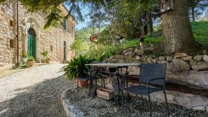 a table and chairs sitting next to a stone wall at Borgo Belfiore in Arcevia
