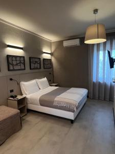 a bedroom with a large white bed and a lamp at Hotel La Pace in San Mauro Torinese