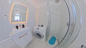 a bathroom with a washing machine and a mirror at Apartment Darlin Berat in Berat +26 photos