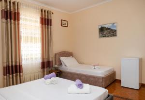 a room with two beds and a window at Apartment Darlin Berat in Berat