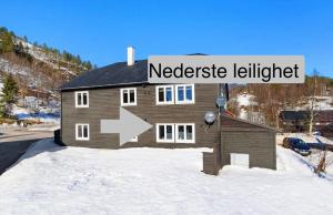 a house in the snow with a sign that reads netisode lighter at Small Cozy apartment with Wi-Fi in Tjørhom