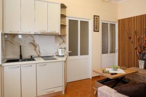 a kitchen with white cabinets and a table in a living room at Apartment Darlin Berat in Berat
