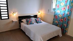 a bedroom with a bed with a white bedspread at Résidence Fleur de Lys in Petit-Bourg