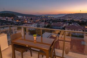 a table on a balcony with a view of a city at Calis Suites Çeşme - Only Family in Çeşme