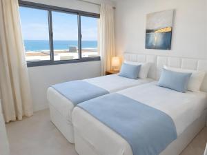 two beds in a bedroom with a view of the ocean at Eden50 in Mijas Costa +30 photos