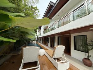 an external view of a house with chairs and a swimming pool at Choox Villa Hotel in Koronadal