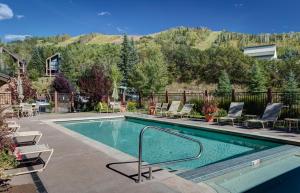 a swimming pool with chaise lounge chairs next to a resort at Bear Claw 104 - Bear Claw I Building in Steamboat Springs