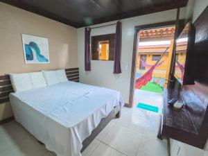 a bedroom with a white bed and a window at Pousada pôr do sol in Riachuelo +59 photos