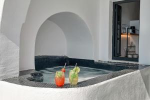 two cocktails sitting on the ledge of a building at Oia Suites in Oia