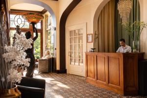 a woman holding up a umbrella in a room with a man at LOGIS Hotel Majestic Chatelaillon Plage - La Rochelle in Châtelaillon-Plage