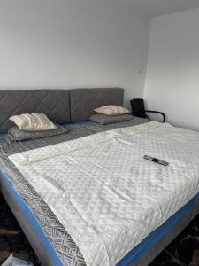 a bed with a remote control sitting on top of it at Villa Violand 3 in Limanu