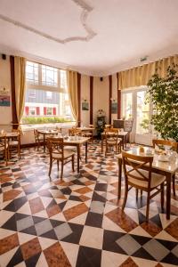 a restaurant with tables and chairs on a checkered floor at LOGIS Hotel Majestic Chatelaillon Plage - La Rochelle in Châtelaillon-Plage
