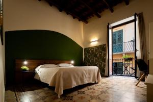 a bedroom with a bed and a green wall at Porta delle Botteghelle in Trapani