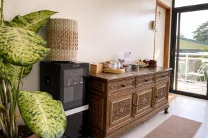 a wooden dresser in a room with a plant at Heidi's Guesthouse in Siquijor