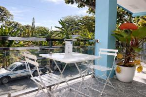 a white table and two chairs on a balcony at Heidi's Guesthouse in Siquijor