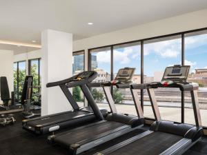a gym with two treadmills and windows at Mercure Jakarta Grogol in Jakarta
