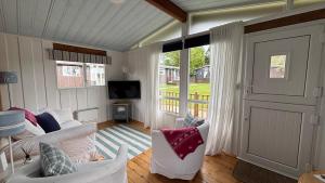 a living room with a couch and a tv at Chalet 24 in Seaton