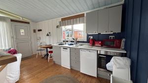 a kitchen with white cabinets and a blue wall at Chalet 24 in Seaton