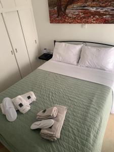 a bed with towels and flip flops on it at Nenas house in Porto Rafti
