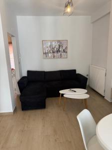 a living room with a black couch and a table at Castle view 2 in Kavála