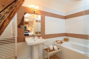 a bathroom with a sink and a bath tub at Chateau le Quesnoy in Chevrières