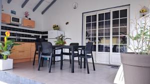 a kitchen with a black dining table and chairs at Résidence Fleur de Lys in Petit-Bourg